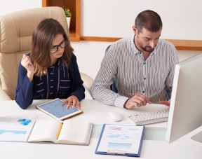 Man and woman analyzing ILM cases studies charts on computer and tablet