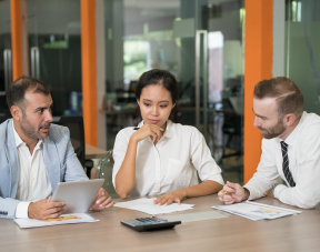 Three colleagues practicing a professional discussion with notes and questions